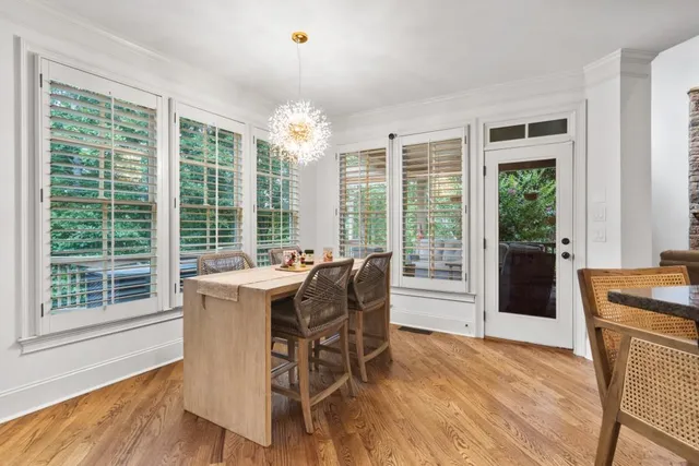 a dining room with furniture wooden floor a chandelier and a mirror