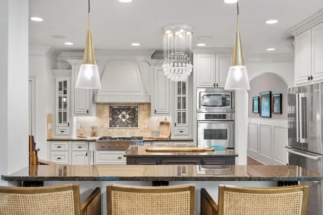a bathroom with a granite countertop bathtub sink vanity mirror and toilet