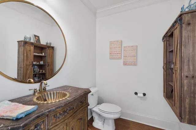 a kitchen with stainless steel appliances granite countertop a stove top oven a sink a dining table and chairs with wooden floor