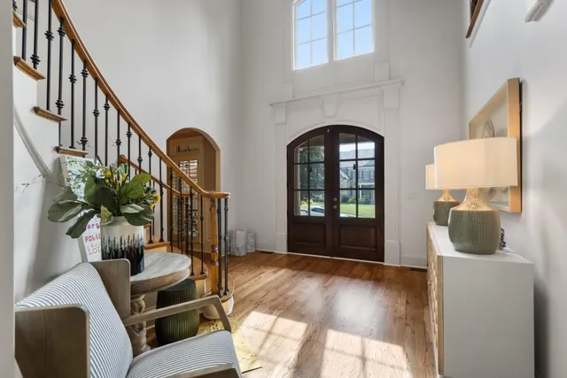 a view of a dining room and livingroom with furniture wooden floor a chandelier