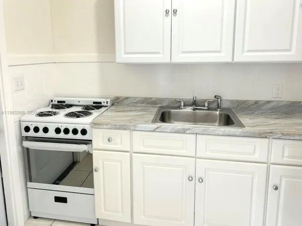 a kitchen with white cabinets and white appliances