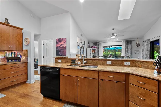 a kitchen with granite countertop a sink stainless steel appliances and cabinets