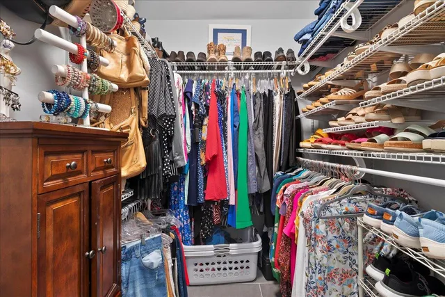 a view of walk in closet with clothes