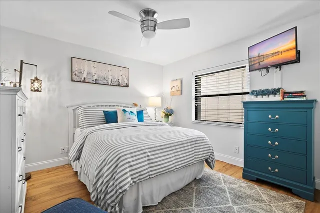 a bedroom with a bed and a flat tv screen on dresser