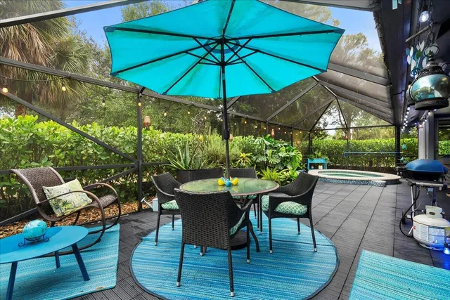 a view of a patio with furniture and table under an umbrella