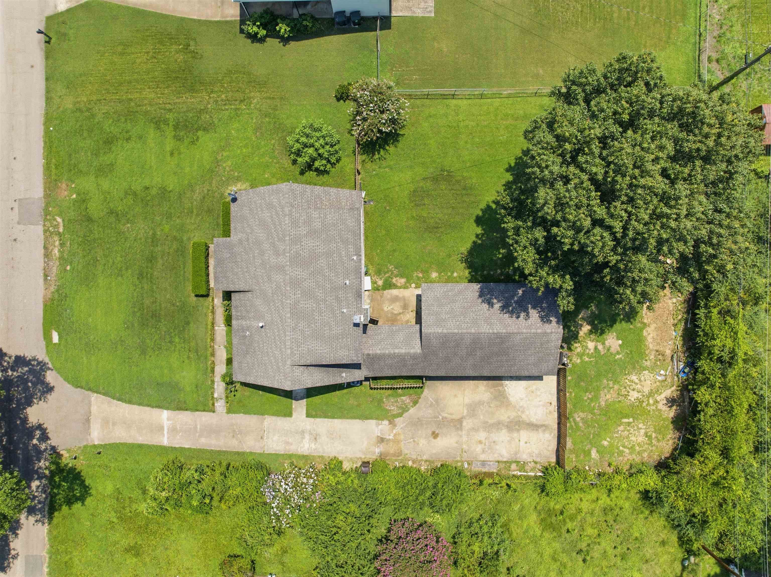 3007 Ruskin Road Bartlett, TN 38134 - Photo 30 of 37 Aerial perspective of a property featuring a gray shingle roof, concrete driveway, and expansive green lawns