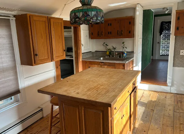 a kitchen with a wooden table chairs and refrigerator