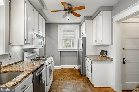 a kitchen with stainless steel appliances granite countertop a sink stove and cabinets