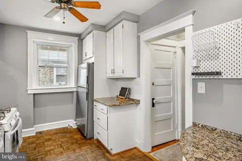 a kitchen with stainless steel appliances granite countertop a refrigerator and a stove top oven