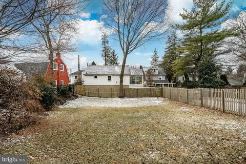 a view of a house with a yard and wooden fence