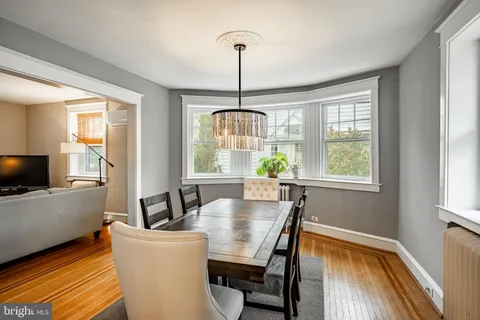 a dining room with furniture a chandelier and wooden floor
