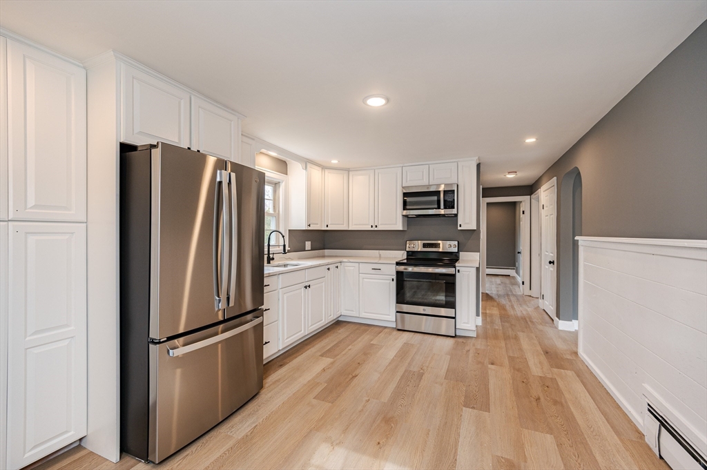 a kitchen with a refrigerator a stove top oven and kitchen island