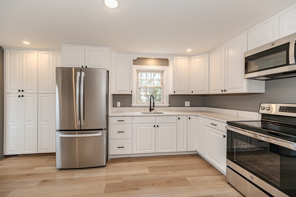 12 Pichowicz Road Billerica, MA 01821 - Photo 8 of 31 a kitchen with stainless steel appliances granite countertop a refrigerator a stove a sink and a microwave