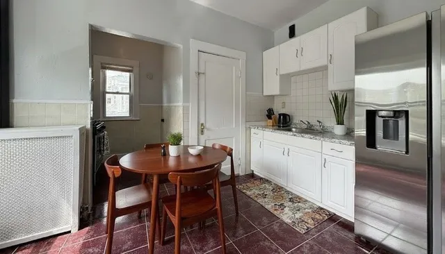 a kitchen with stainless steel appliances kitchen island granite countertop a sink a stove a table and chairs