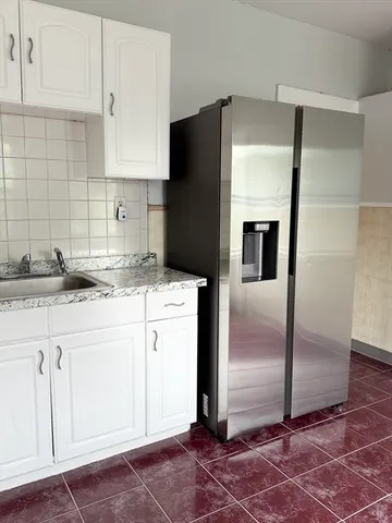 a kitchen with granite countertop a refrigerator and a sink