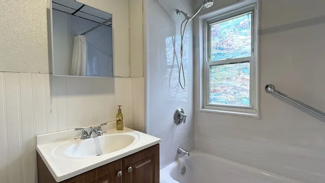 a bathroom with a sink vanity tub and a mirror