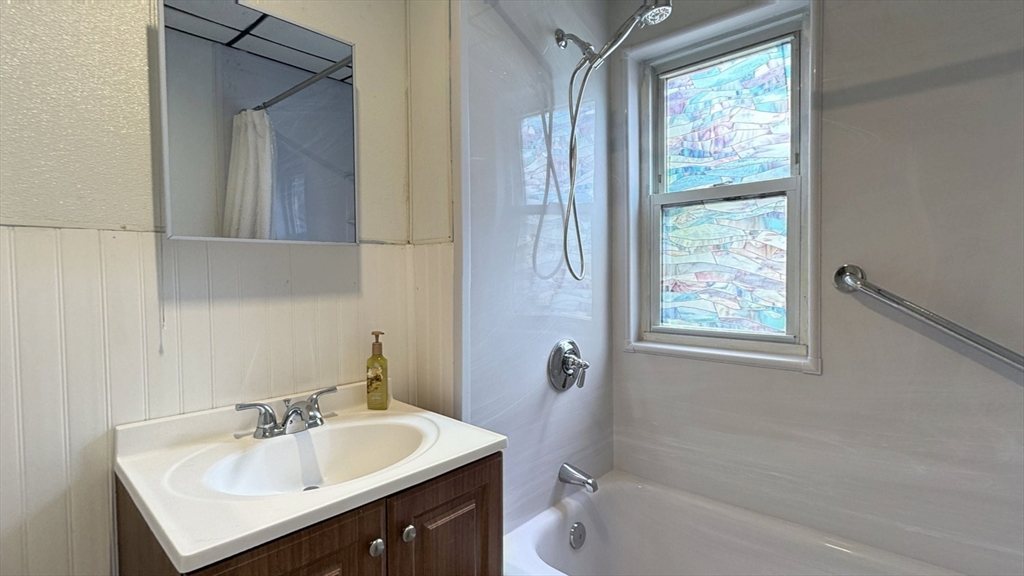 106 Beaumont Street, Unit 1 Boston, MA 02124 - Photo 8 of 15 a bathroom with a sink vanity tub and a mirror