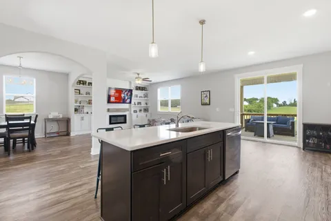 a kitchen with kitchen island a sink stove and wooden floor