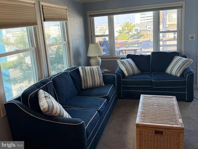 a living room with furniture and a floor to ceiling window