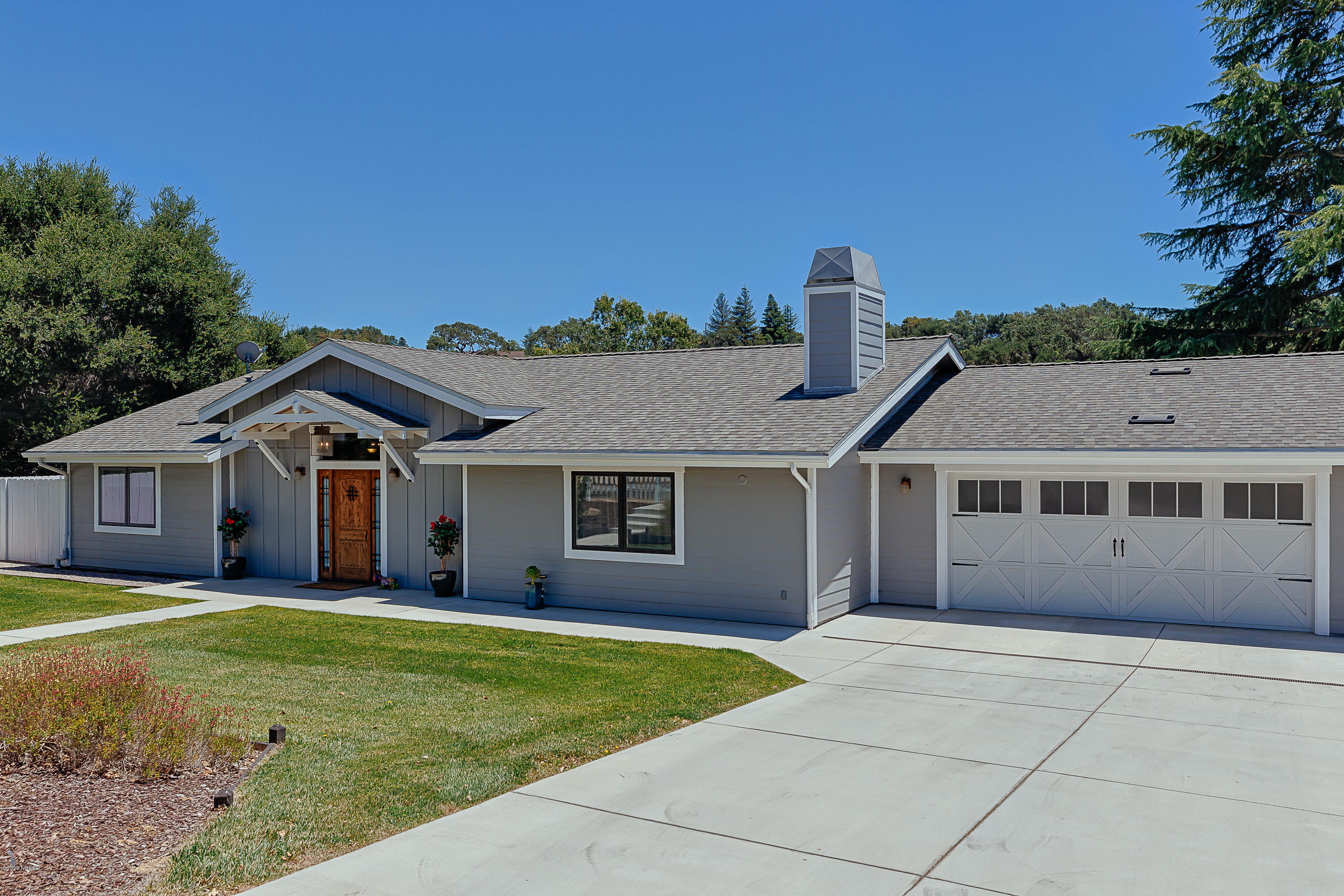 a view of a house with a yard and large tree
