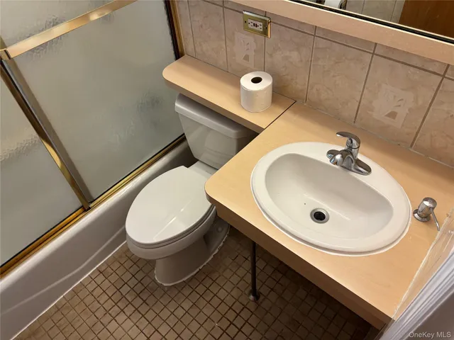 a bathroom with a sink toilet and a mirror