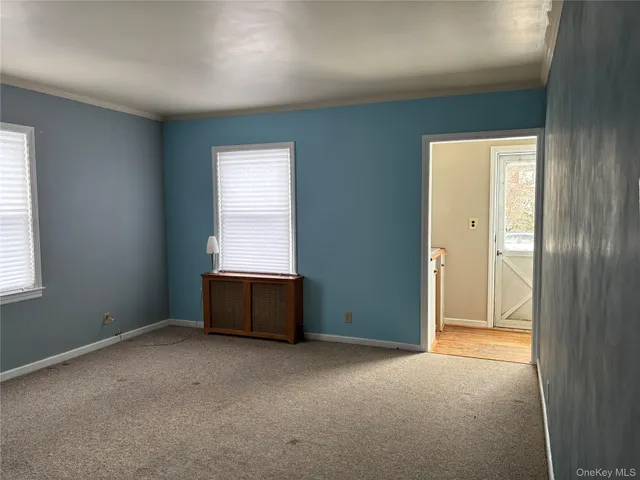 an empty room with a window and wooden floor