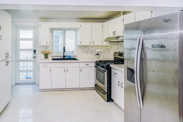 a kitchen with stainless steel appliances a refrigerator sink and cabinets