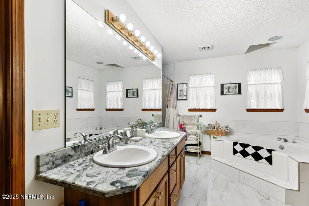 45235 Stratton Road Callahan, FL 32011 - Photo 15 of 44 a en suite bathroom with a granite countertop double vanity and a mirror