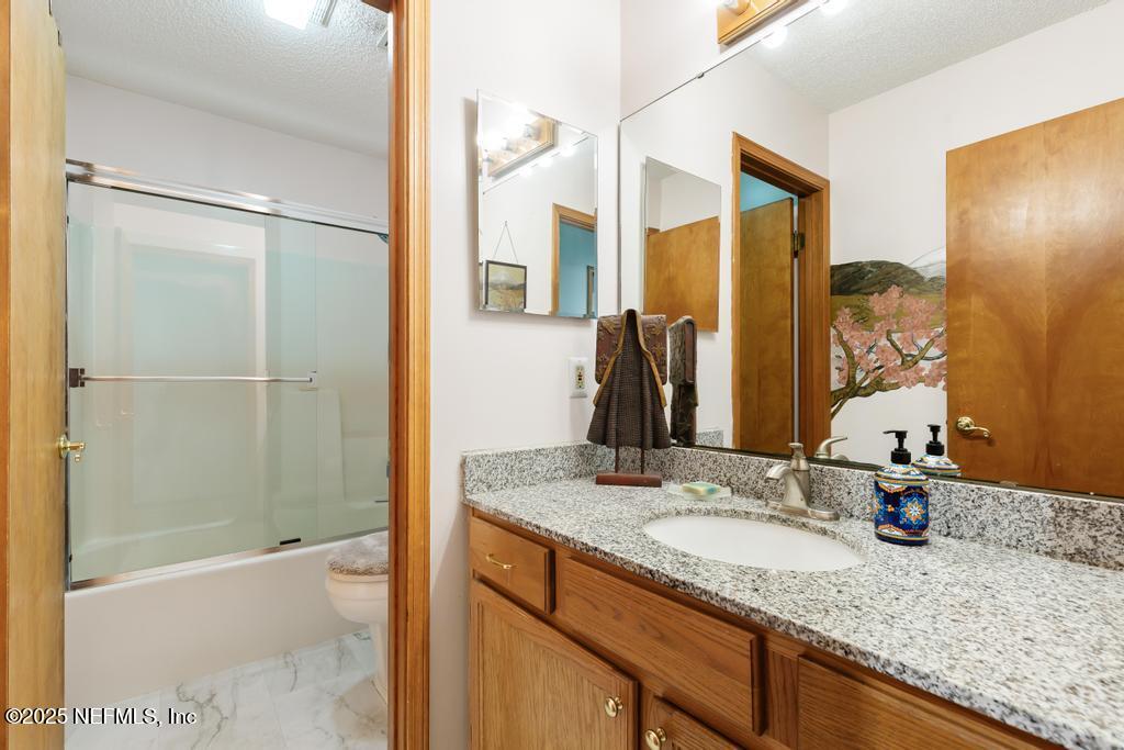 45235 Stratton Road Callahan, FL 32011 - Photo 22 of 44 a bathroom with a granite countertop sink and a mirror