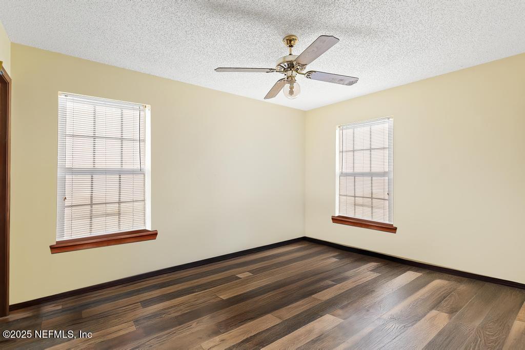 45235 Stratton Road Callahan, FL 32011 - Photo 25 of 44 an empty room with wooden floor fan and windows