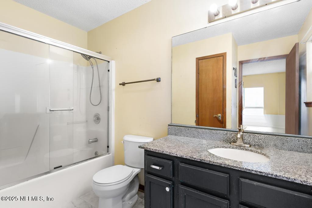 45235 Stratton Road Callahan, FL 32011 - Photo 27 of 44 a bathroom with a granite countertop sink toilet and shower