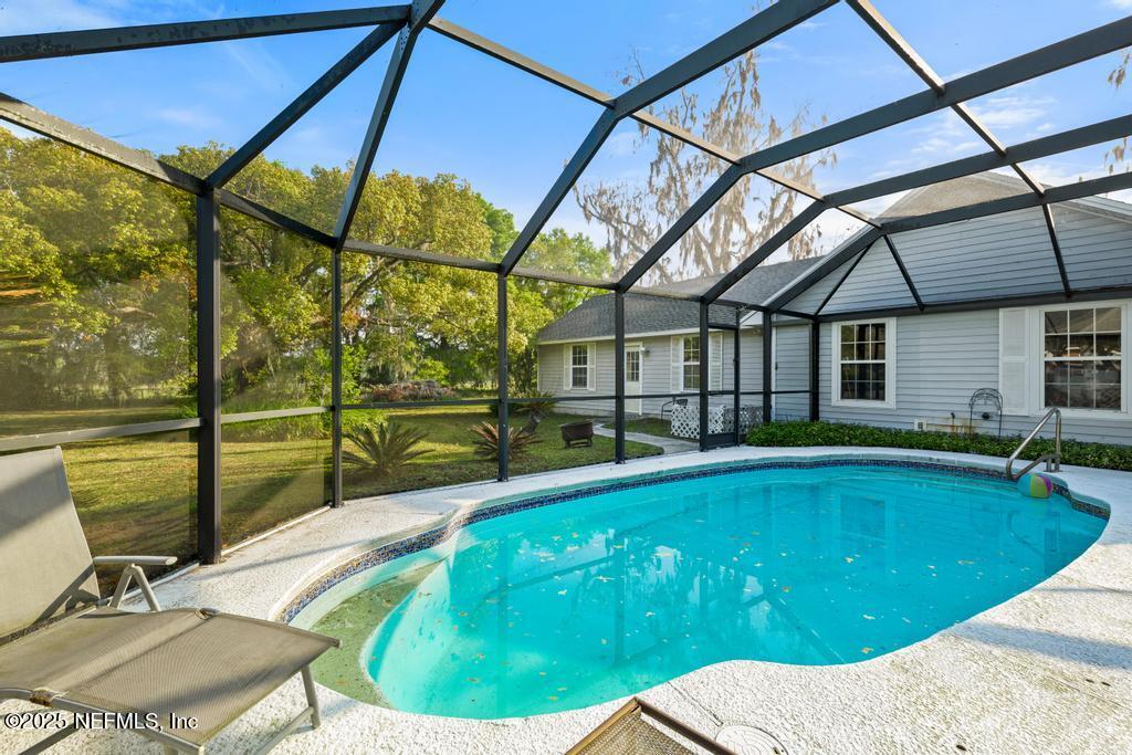 45235 Stratton Road Callahan, FL 32011 - Photo 33 of 44 a swimming pool with large glass windows and painted walls