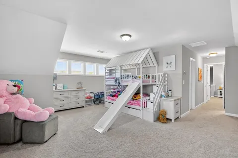 a view of an empty room with furniture and a window