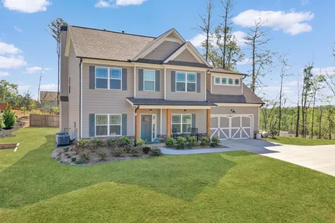 a front view of a house with a yard and potted plants