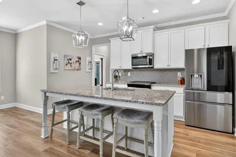 a kitchen with kitchen island granite countertop a center island a sink cabinets and stainless steel appliances