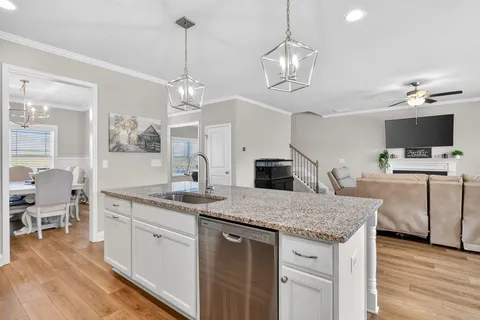 a kitchen with kitchen island granite countertop a center island a sink stainless steel appliances and cabinets