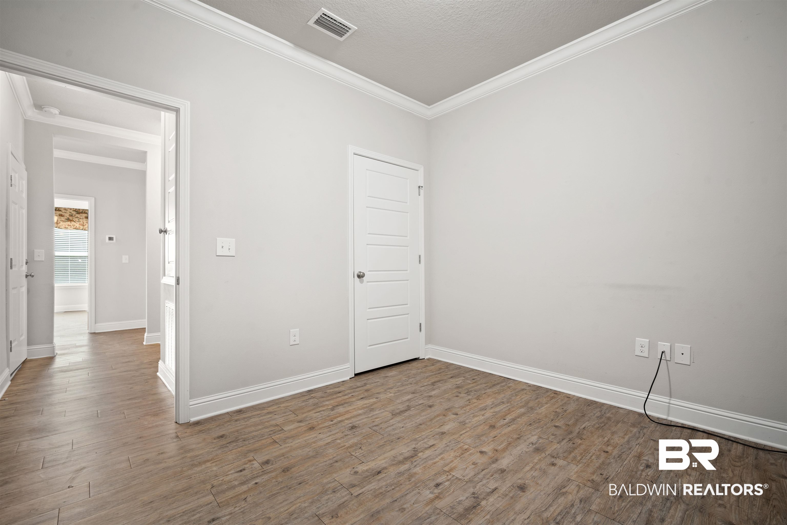 24479 Kipling Court Daphne, AL 36526 - Photo 18 of 41 Unfurnished room featuring crown molding, dark wood-style floors, and a textured ceiling