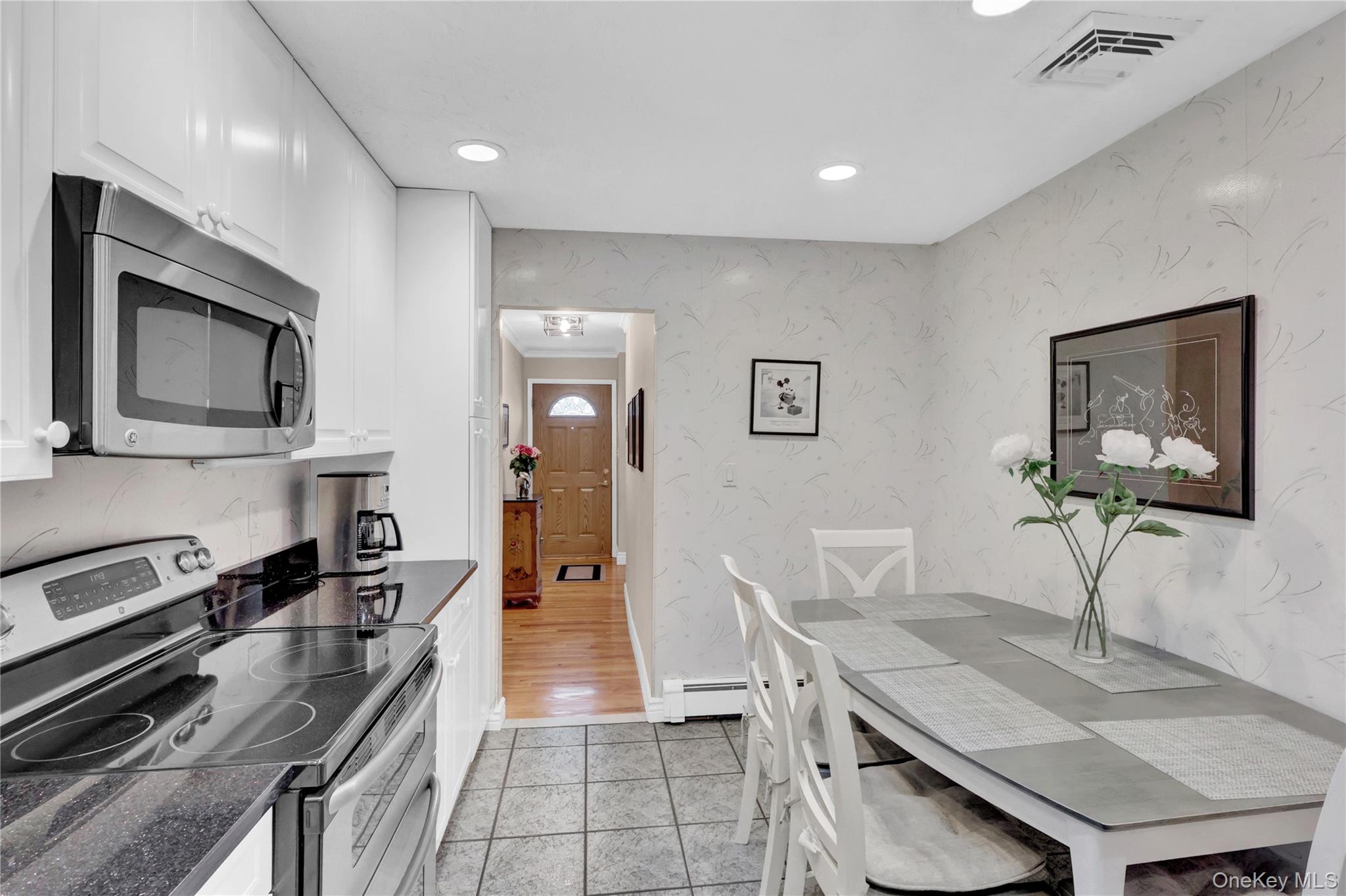 46 Kalda Lane Plainview, NY 11803 - Photo 17 of 30 a kitchen with stainless steel appliances granite countertop a stove top oven a sink a dining table and chairs with wooden floor