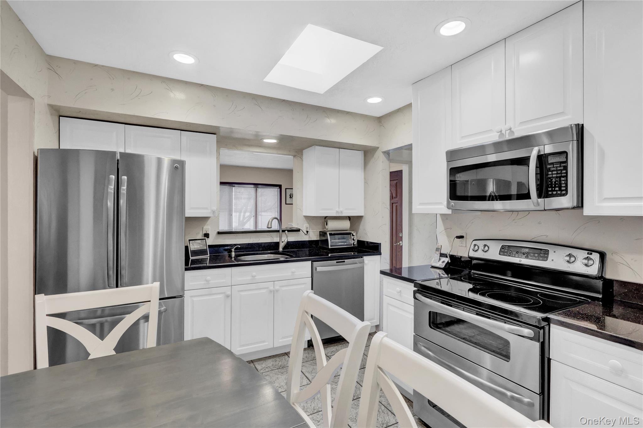 46 Kalda Lane Plainview, NY 11803 - Photo 18 of 30 a kitchen with stainless steel appliances a stove a sink a microwave and cabinets
