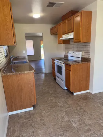a kitchen with stainless steel appliances granite countertop a stove a sink and a refrigerator