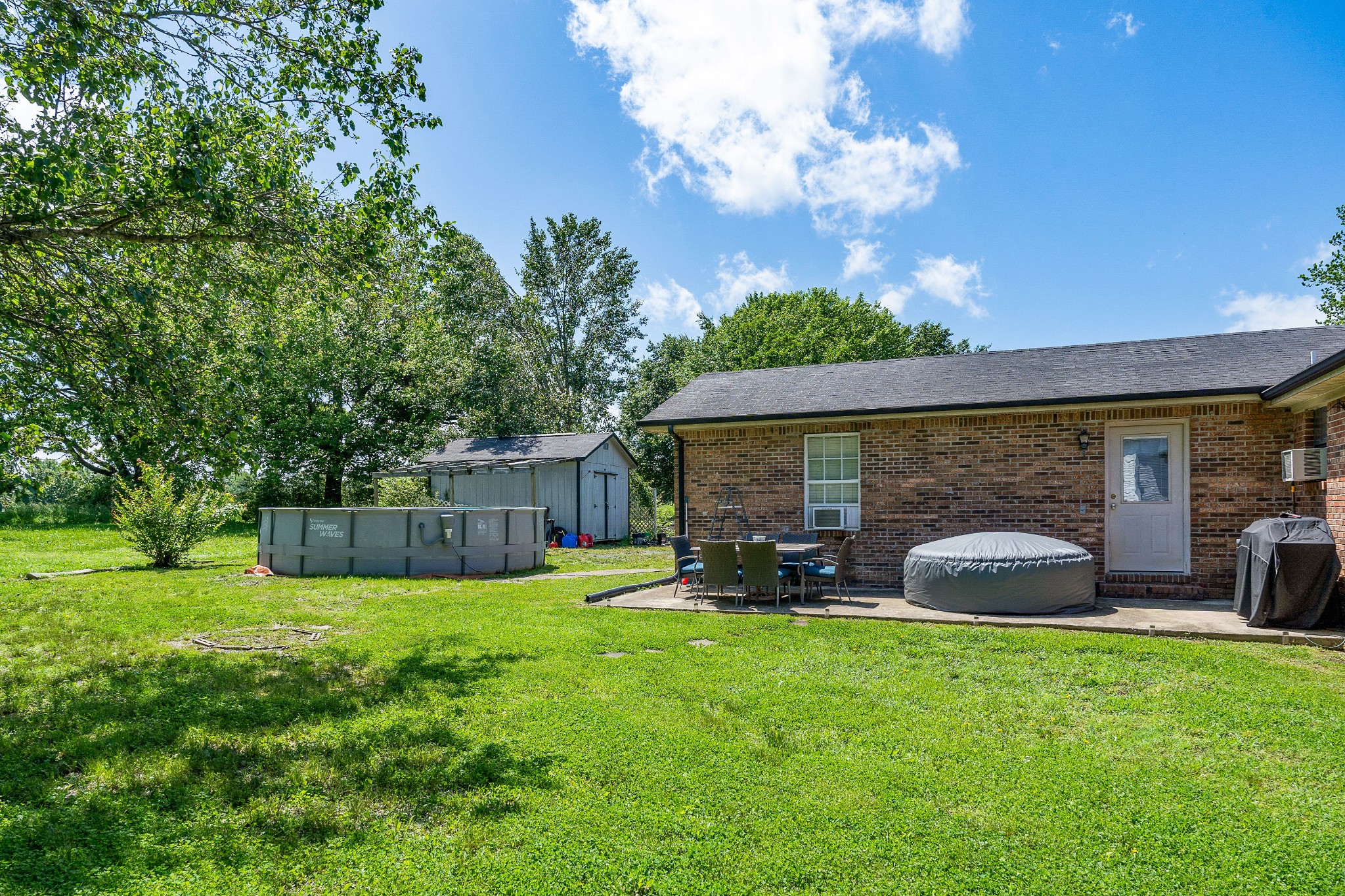 409 Kendra Drive Smithville, TN 37166 - Photo 25 of 27 a view of a patio with table and chairs under an umbrella