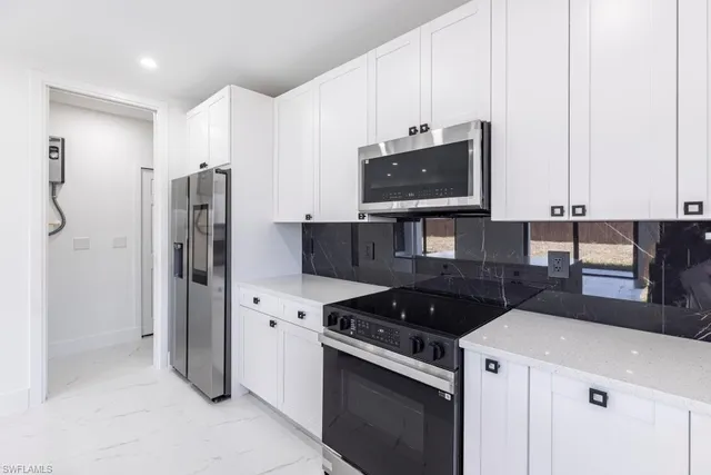 a kitchen with stainless steel appliances a refrigerator sink and microwave