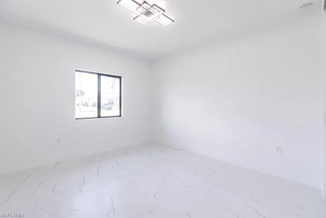 an empty room with a ceiling fan and a window