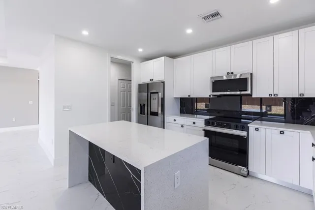 a view of an empty room with wooden floor and windows