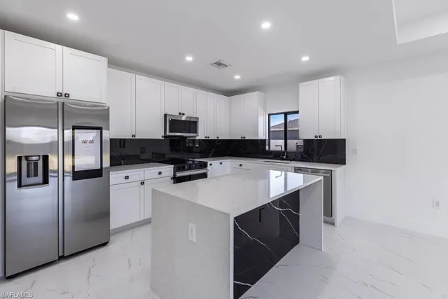 a kitchen with stainless steel appliances a stove microwave and refrigerator