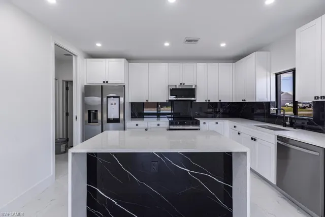 a kitchen with kitchen island a refrigerator sink and microwave