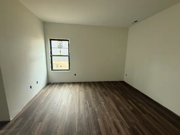 a view of a room with wooden floor and window