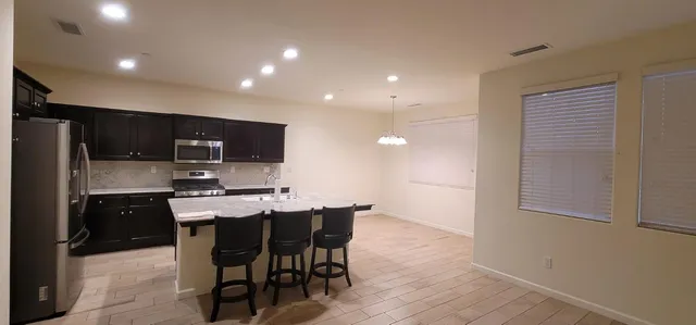 a kitchen with stainless steel appliances kitchen island granite countertop a sink and cabinets