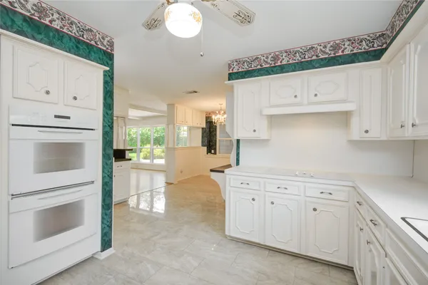 a kitchen with white cabinets and white appliances