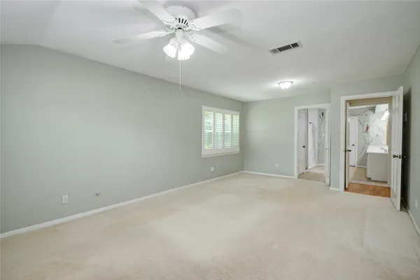 an empty room with windows and fan